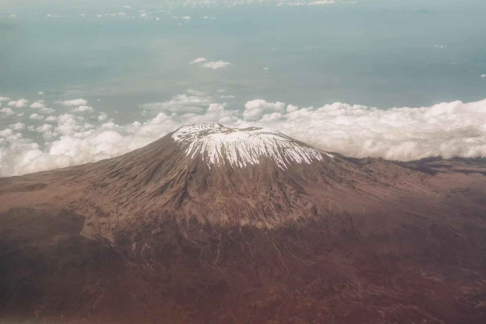 Climbers ascending toward the summit of Mount Kilimanjaro at sunrise